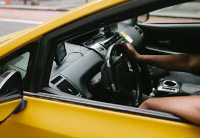 ethnic man driving taxi equipped with navigator