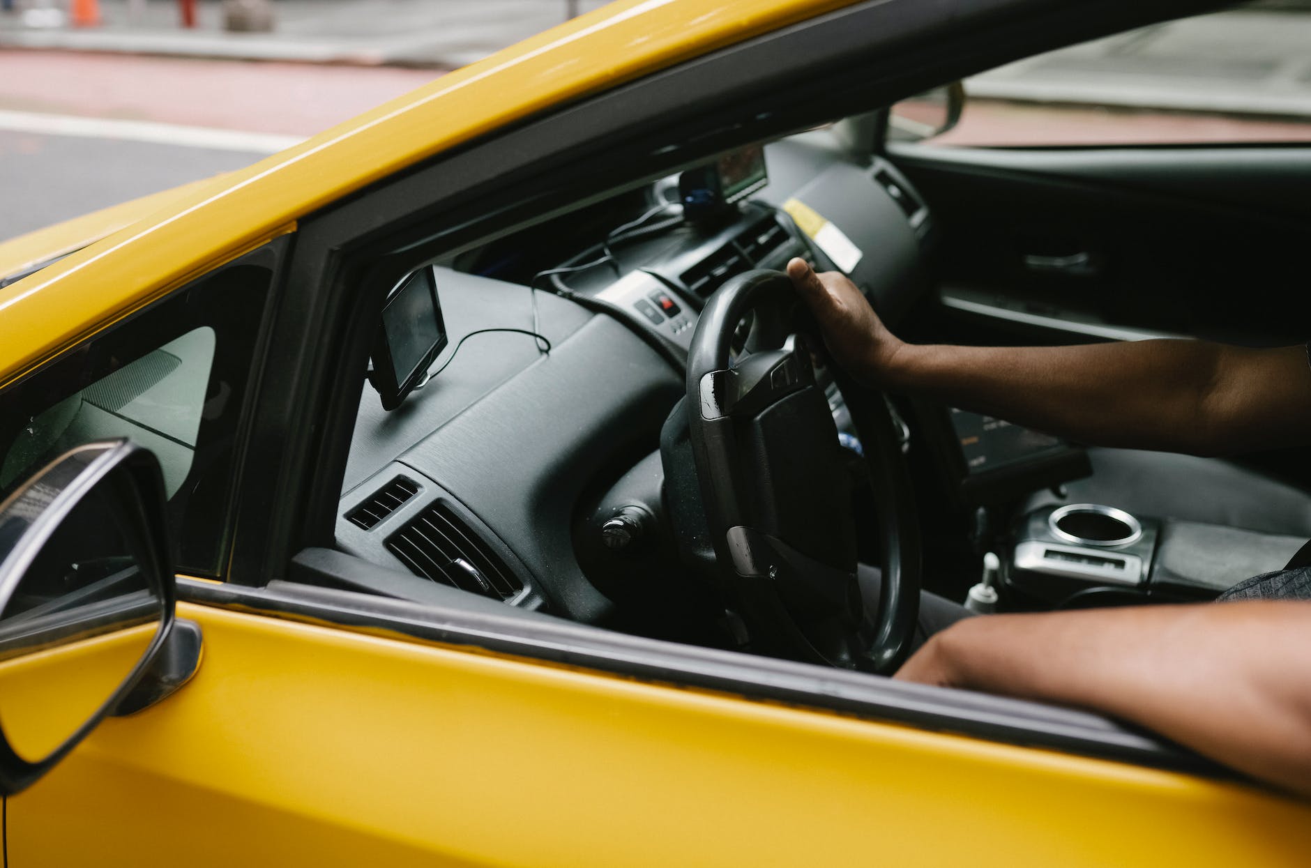 ethnic man driving taxi equipped with navigator